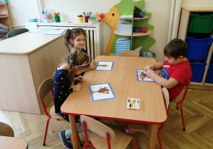 dzieci wykonują prace przy stolikach